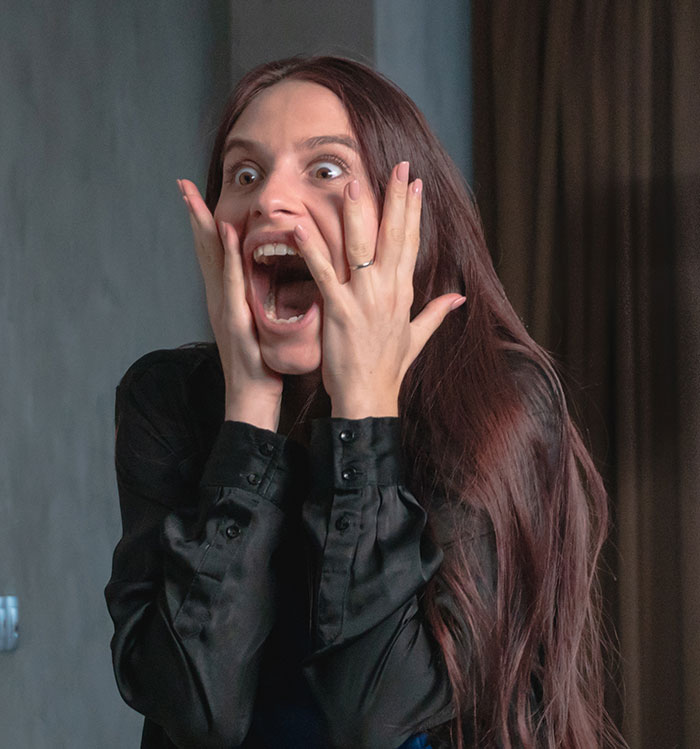 Young woman showing shocked expression, illustrating things people only started to believe once it happened to them.