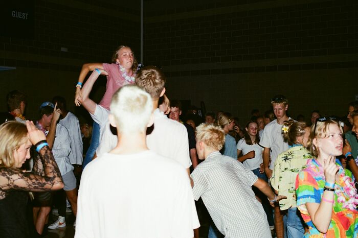 Crowd of young people at a party, showing signs of being stuck in their high school era years later.