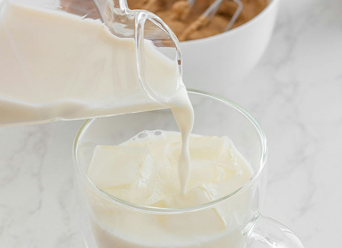 Glass mug with ice cubes being filled with milk from a clear pitcher, illustrating the mammalian dive reflex concept.