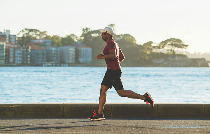 Man running outdoors near water demonstrating the mammalian dive reflex related to human body facts.