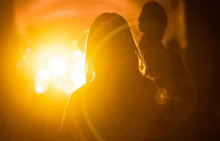 Silhouettes of two people against intense golden sunlight, illustrating the mammalian dive reflex in the human body.