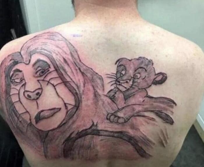 Tattoo of two cartoon lions on a person's back with poor quality and awkward shading in an online worst tattoos group.