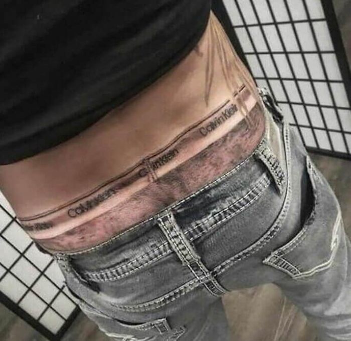 Tattoo of Calvin Klein underwear waistband on lower back, showcasing one of the worst tattoos shared by an online group.