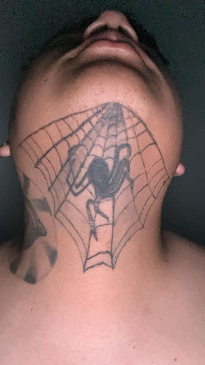 Close-up of a neck tattoo featuring a spider and web, representing one of the worst tattoos shared in an online group.