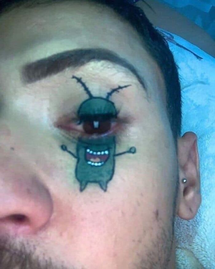 Tattoo of a cartoon character around a person's eye, showing a worst tattoo from an online group collection.