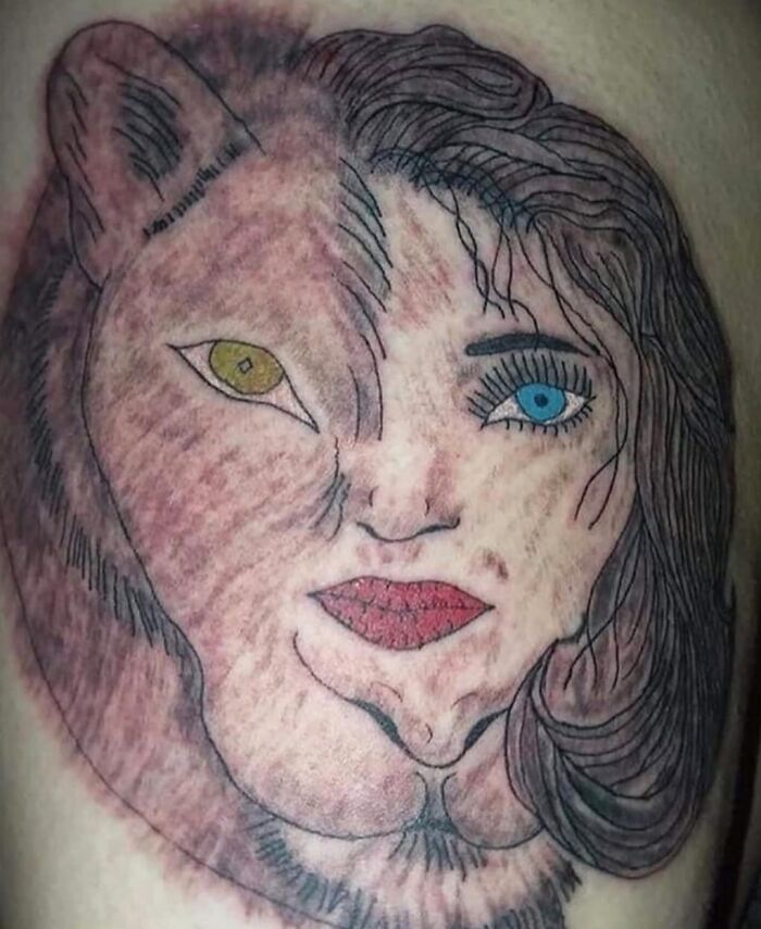 Tattoo blending a lion face and a woman’s face with mismatched eyes and rough line work, showcasing worst tattoos out there.