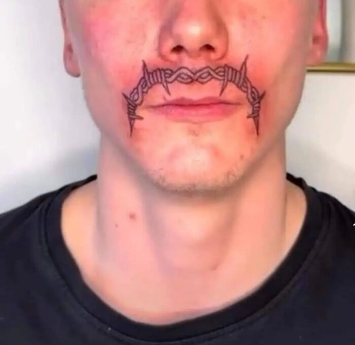 Young man with a barbed wire tattoo across his upper lip, featured in a group dedicated to the worst tattoos.