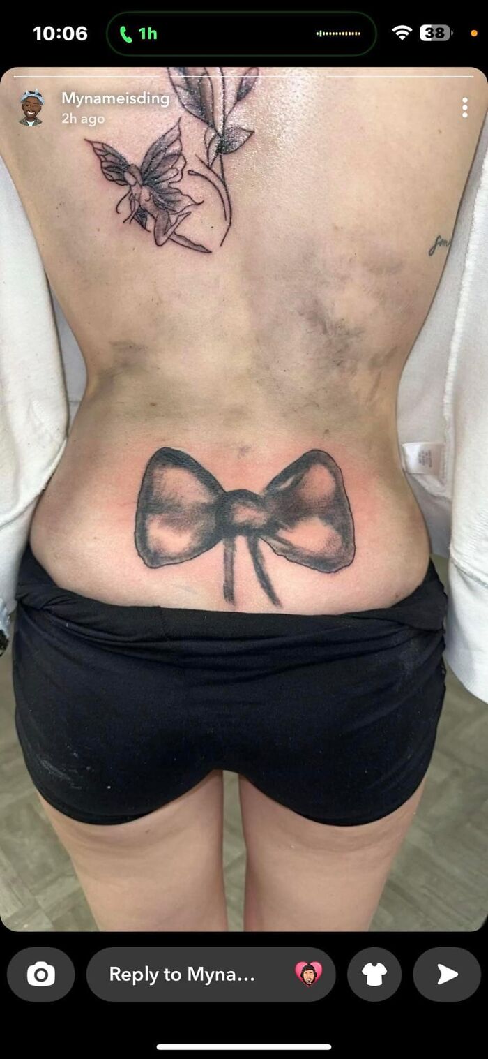 Black and pink bow tattoo on lower back shown as part of worst tattoos shared in an online group.
