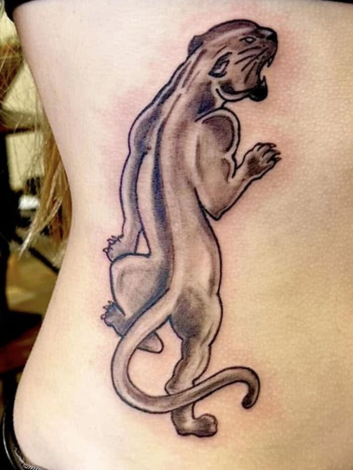 Tattoo of a panther with distorted anatomy on a person's side, showcasing one of the worst tattoos in an online tattoo group.