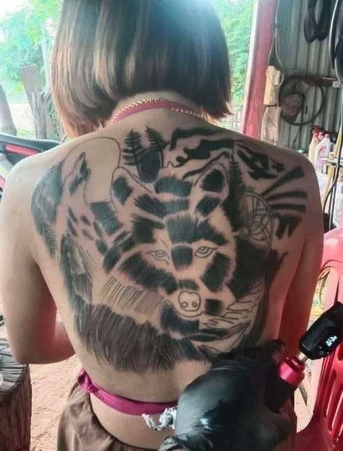 Person getting a large wolf tattoo on their back, featured in an online group dedicated to the worst tattoos out there.