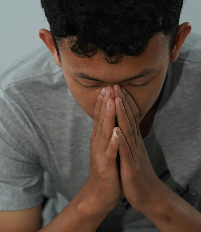 Teen with hands clasped in reflection, illustrating the secretly gay teen teaching homophobic parents a lesson on respect.