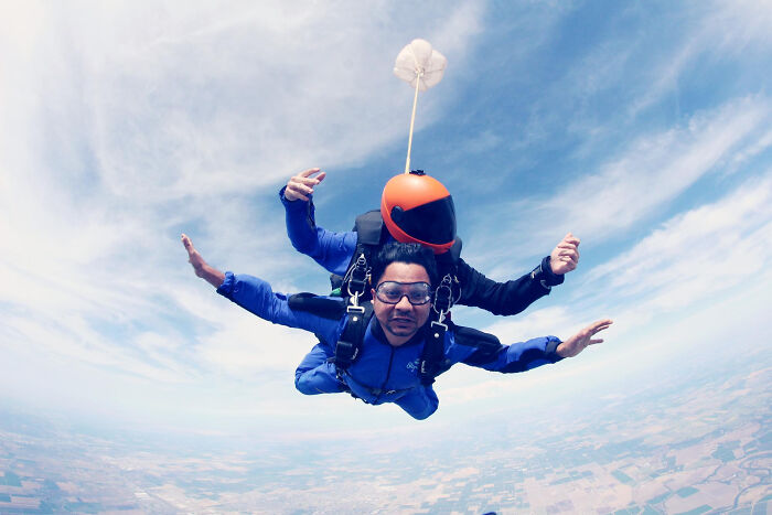 Two people skydiving during a tandem jump, highlighting overrated and overpriced must-try experiences in adventure activities.