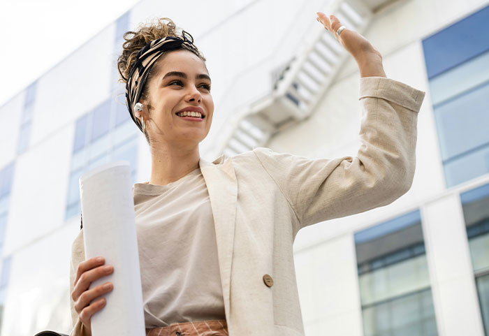 Young confident female roasting men with a smart expression while standing outdoors in a modern urban setting