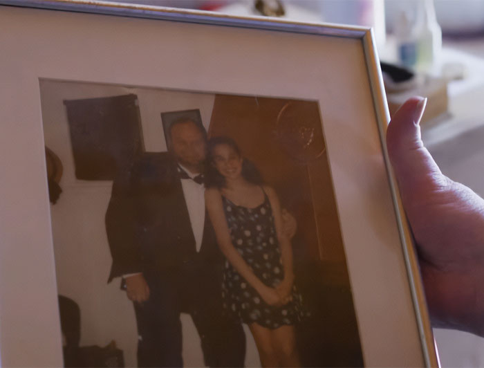 Hand holding a framed photo of a man and a young woman, related to Meghan Markle and estranged hospitalized father controversy. Hand holding a framed photo of a man and a young woman, related to Meghan Markle and estranged hospitalized father controversy.