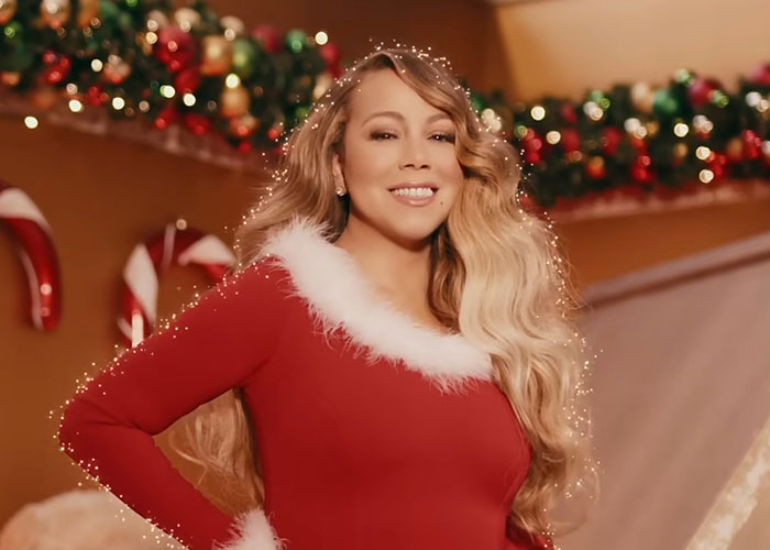 Woman in festive red outfit with white fur trim smiling in holiday-decorated room illustrating interesting today I learned facts