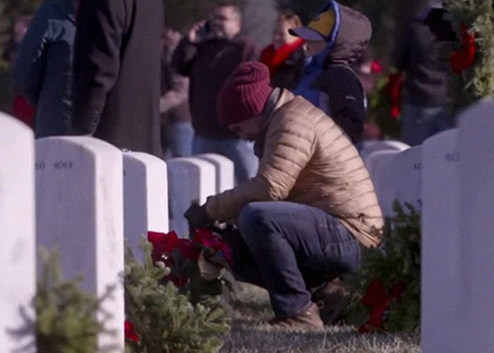 Person placing flowers at a grave in a cemetery, illustrating thoughtful moments and interesting today I learned facts.