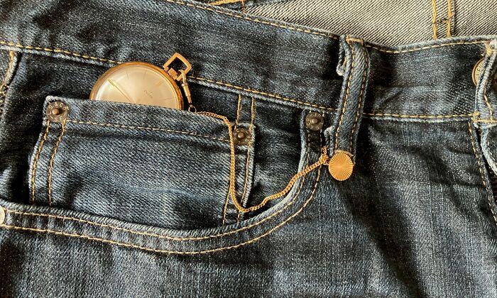 Pocket watch stuck in a small denim pocket showing a common small design mistake causing user annoyance