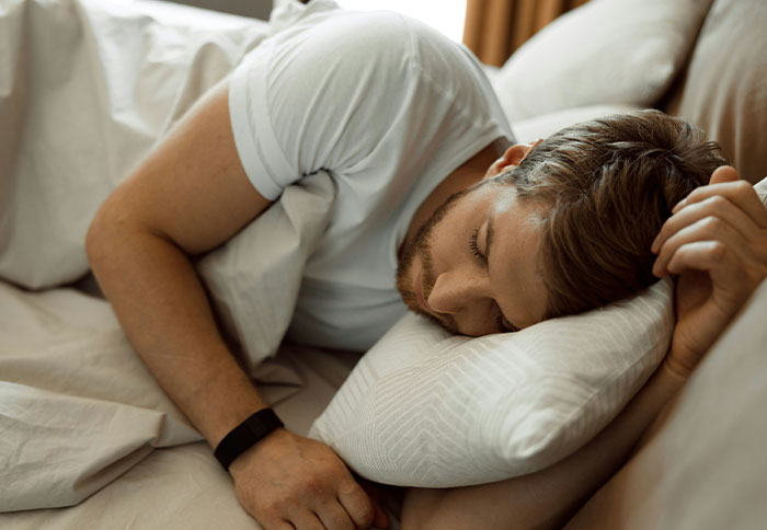 A man sleeping on a bed with a pillow, illustrating dad privileges that feel like a slap in the face.