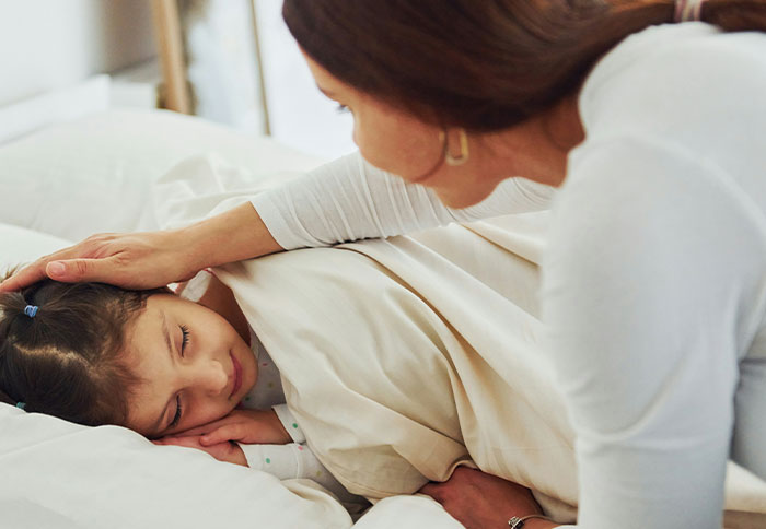 Mom comforting her child in bed, illustrating the dad privileges that feel like a slap in the face discussion.