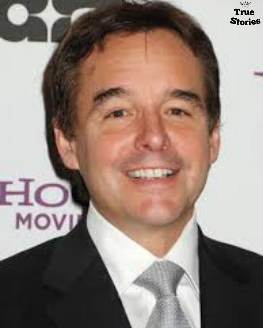 Smiling American man in a suit and tie at an event, representing important American personalities you might not know.