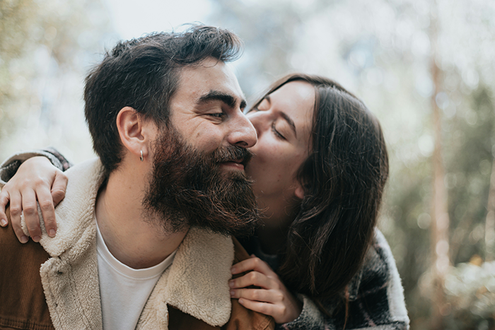 Couple outdoors with woman kissing man on cheek, illustrating SAHM feeling poor despite monthly fun money from husband.