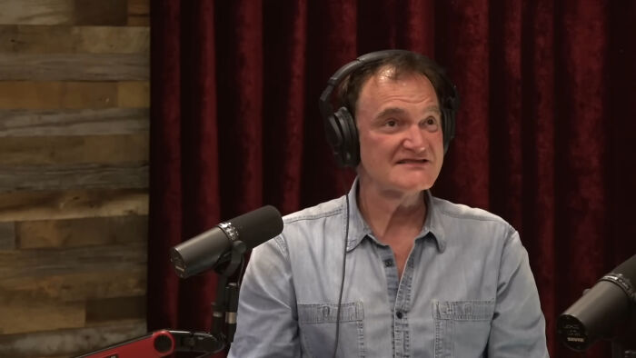 Man in headphones speaking into a microphone during a podcast discussing people think celebrities closet skeletons.