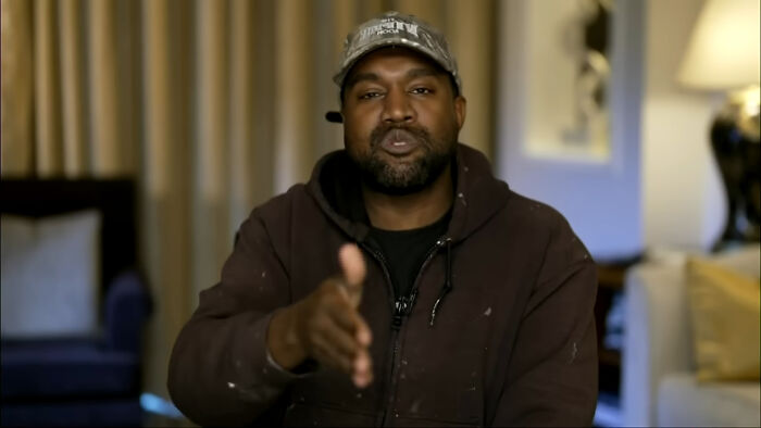 Man in a brown hoodie and cap speaking in a casual indoor setting about celebrities people think suffer.