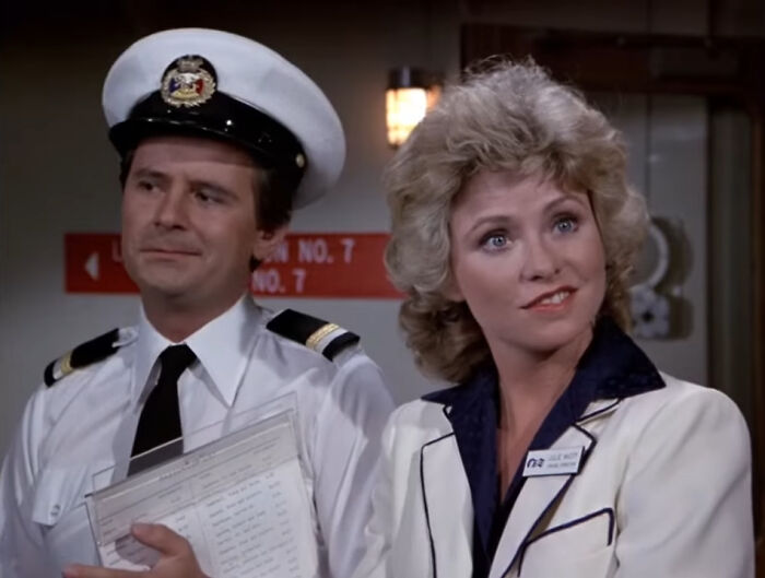 Two characters in a scene from a show, one in a naval uniform and the other in a white blazer, representing once famous regular job.