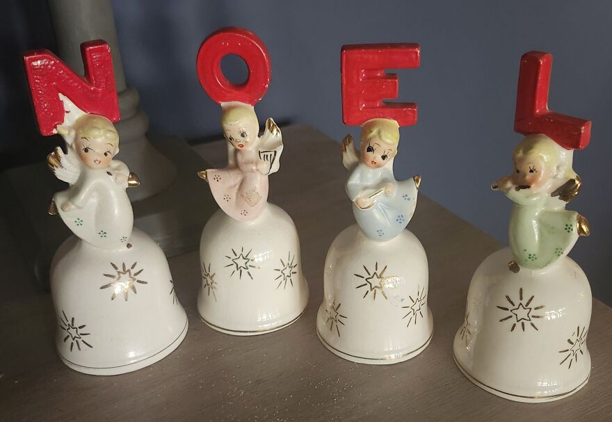 Set of vintage Christmas decorations featuring four angel figurines holding red letters spelling NOEL on bells.