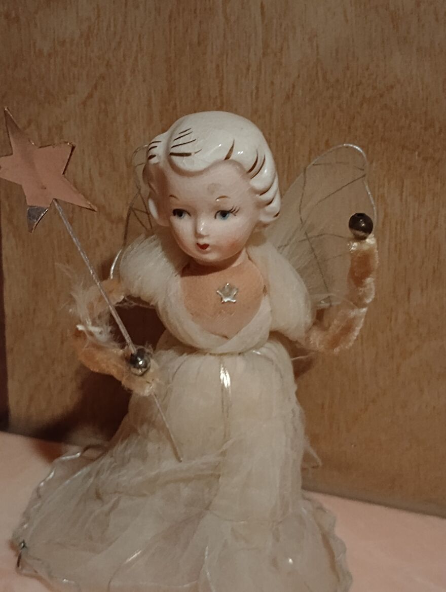 Vintage Christmas decoration featuring a delicate angel figurine with a star wand and sheer fabric dress.