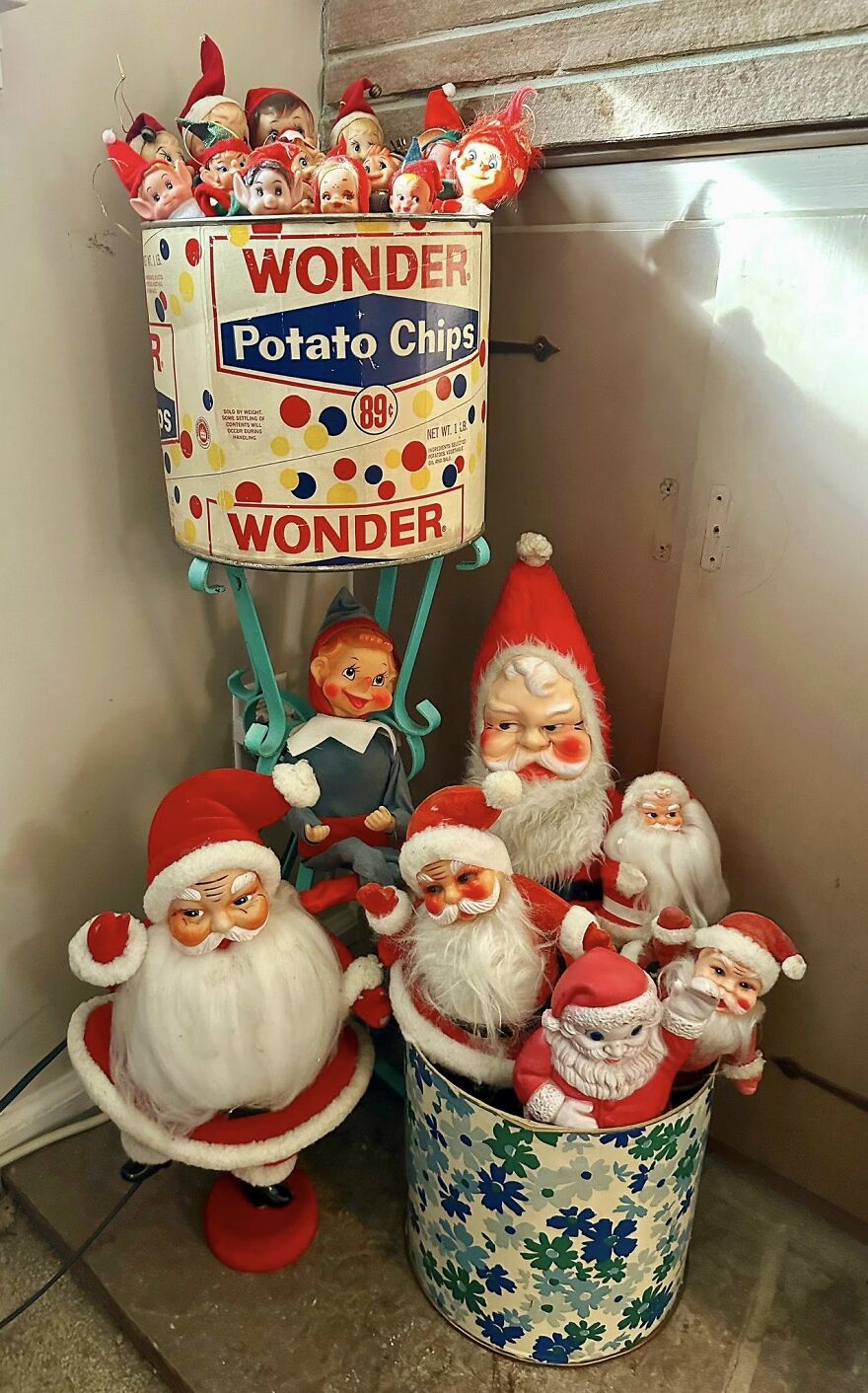 Vintage Christmas decorations featuring retro Santa and elf dolls displayed in colorful nostalgic containers.
