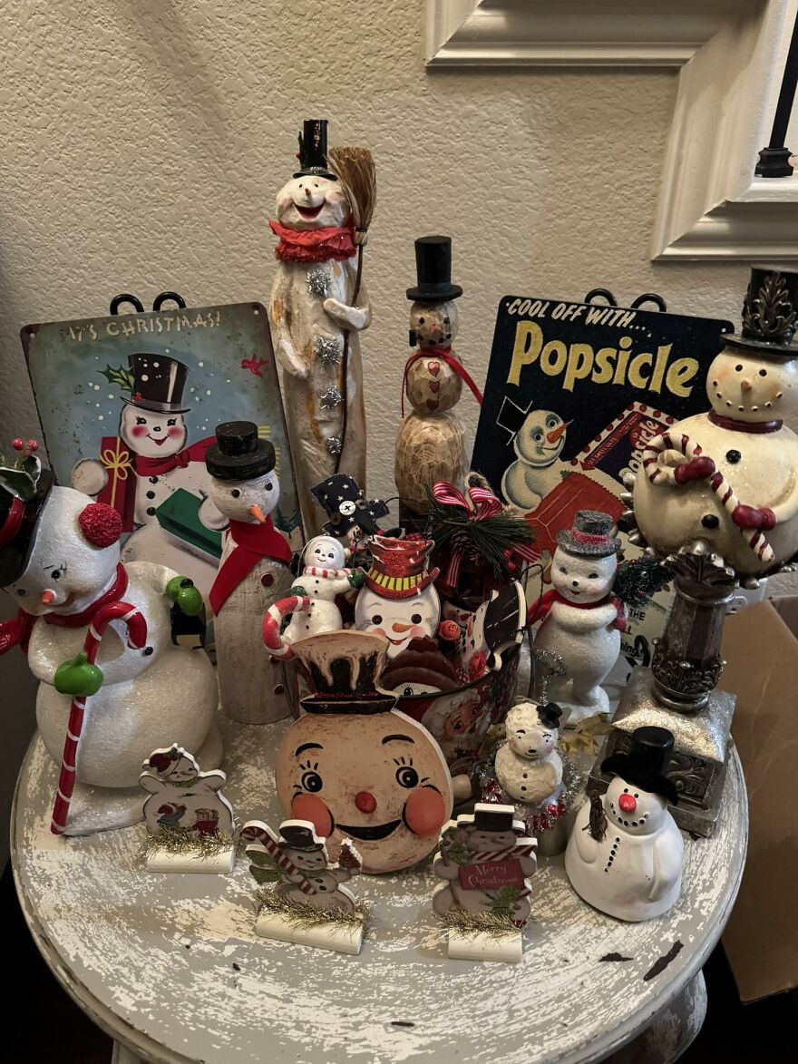 Vintage Christmas decorations featuring snowmen, candy canes, and nostalgic holiday figures on a rustic white table.