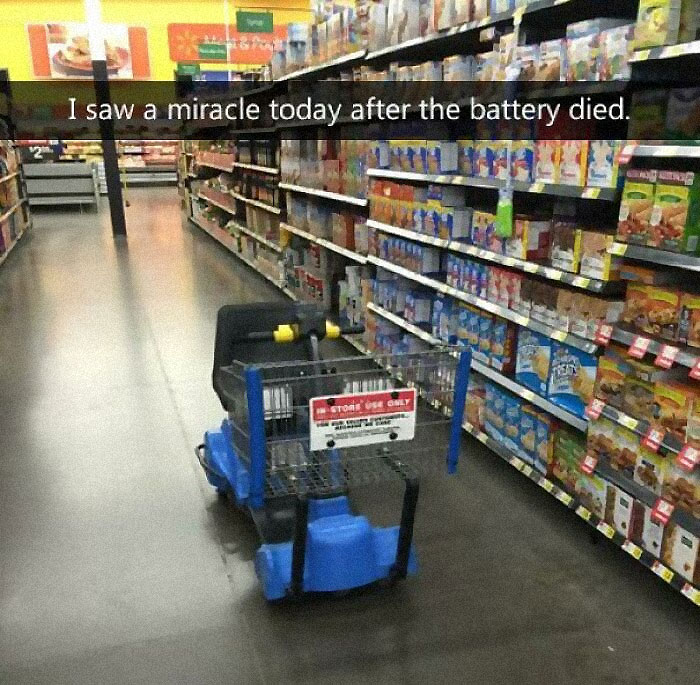 Walmart people shopping aisle with a battery-powered cart stopped and a humorous sign about the battery dying