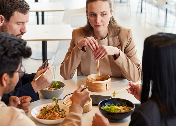 Grupo de personas comiendo en restaurante conversando sobre historias de consecuencias no intencionadas y celos.