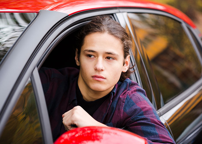 Young man looking out car window reflecting on wild cause-and-effect moments that went in unexpected directions.