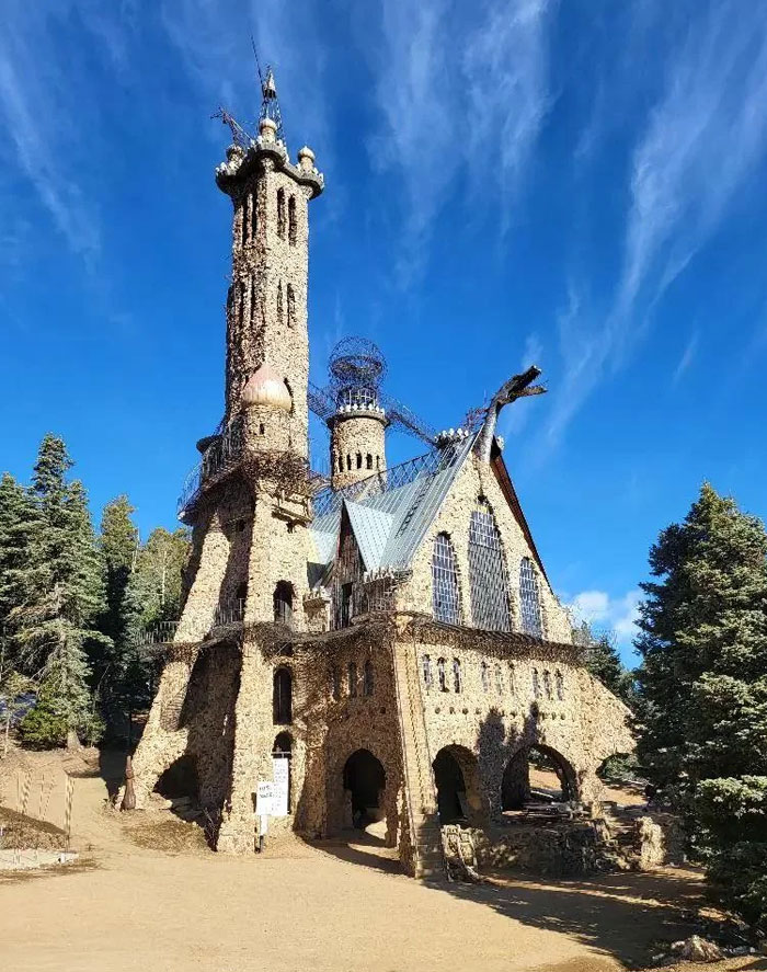 Unusual bread-shaped bread factory building with tall towers and intricate stonework under a clear blue sky.