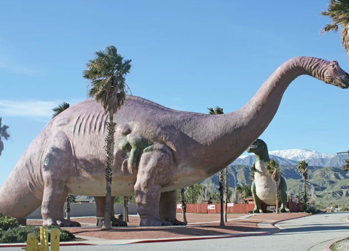 Large dinosaur-shaped building at a roadside attraction, showcasing one of the weirdest buildings from around the world.
