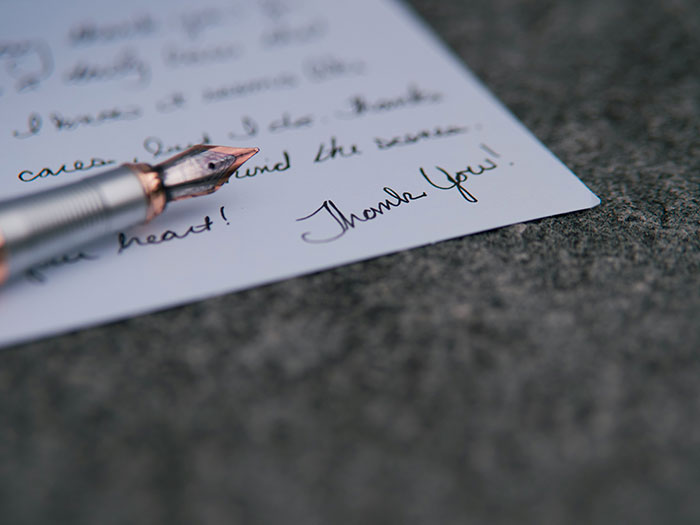 Fountain pen resting on a handwritten note, symbolizing a teacher's message sparking a mom's furious reaction.