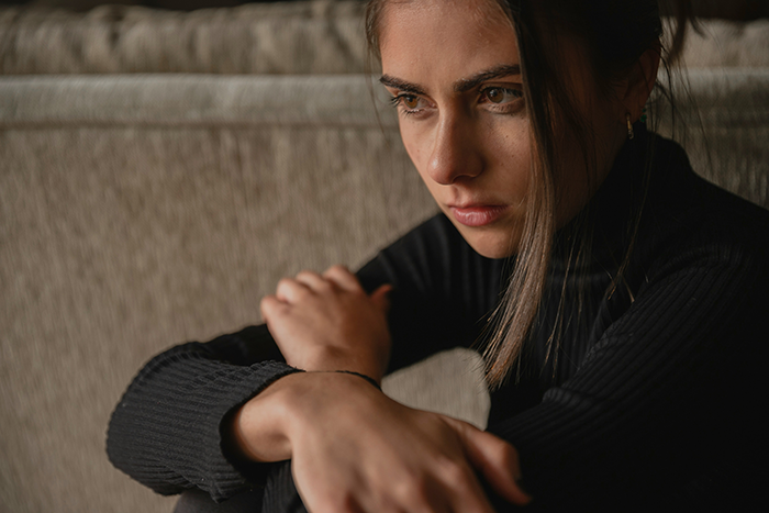 Woman sitting on a couch looking upset, reflecting feelings about boyfriend’s comment on future kids and love for boys only. Woman sitting on a couch looking upset, reflecting feelings about boyfriend’s comment on future kids and love for boys only.