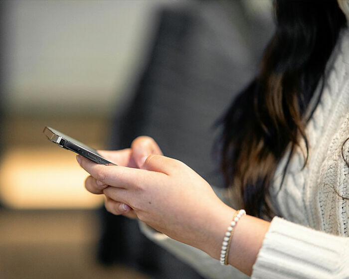 Woman holding smartphone, reacting quickly on a date, reflecting what a jerk behavior in less than 2 minutes.