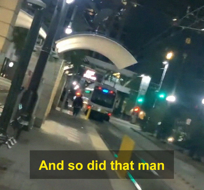 Nighttime street scene with a woman scaring off men stalkers near a tram station using a period pad.