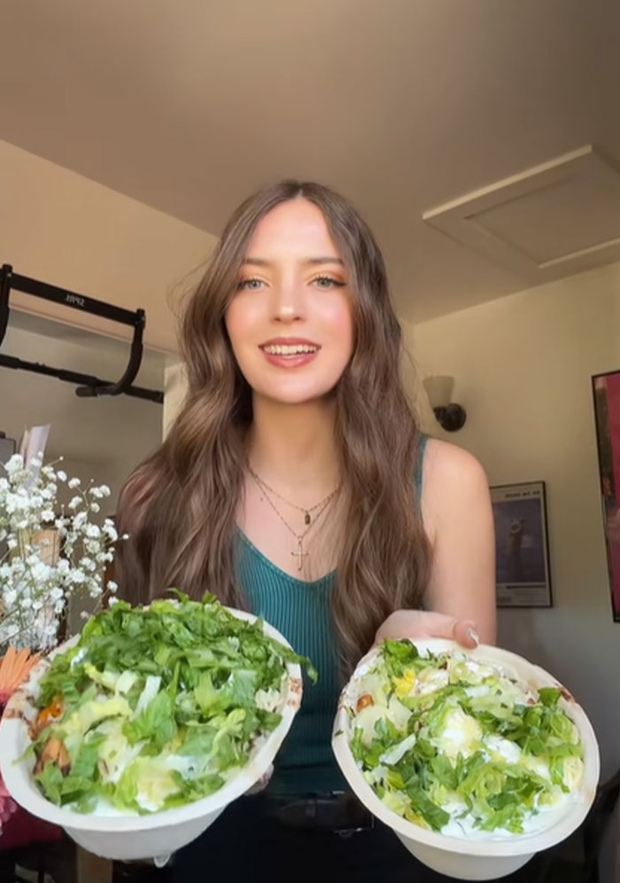 Young woman testing Chipotle food portions in orders placed under male names, holding two bowls with fresh ingredients.