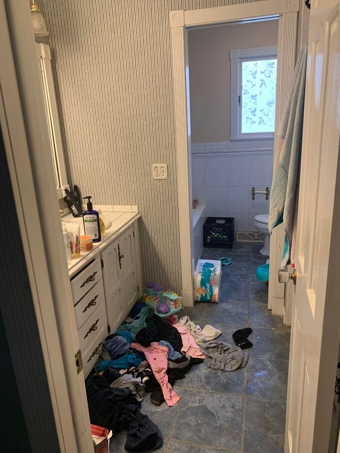 Baño desordenado con ropa en el suelo, señal común de red flags que notan profesionales del hogar.