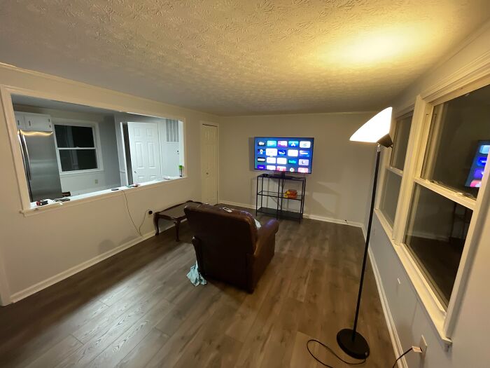 Sala de estar mínima con piso de madera, luz tenue y detalles que alertan a profesionales del hogar sobre señales silenciosas.