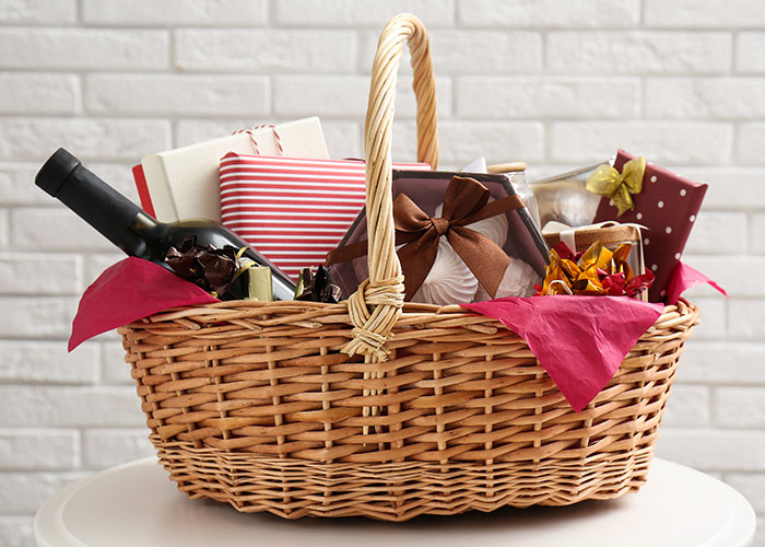 Gift basket filled with wrapped presents and a wine bottle, illustrating insensitive and tasteless gift ideas like a gym membership.