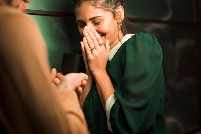 Woman reacting with surprise and joy during a marriage proposal, illustrating the worst proposal stories keyword.
