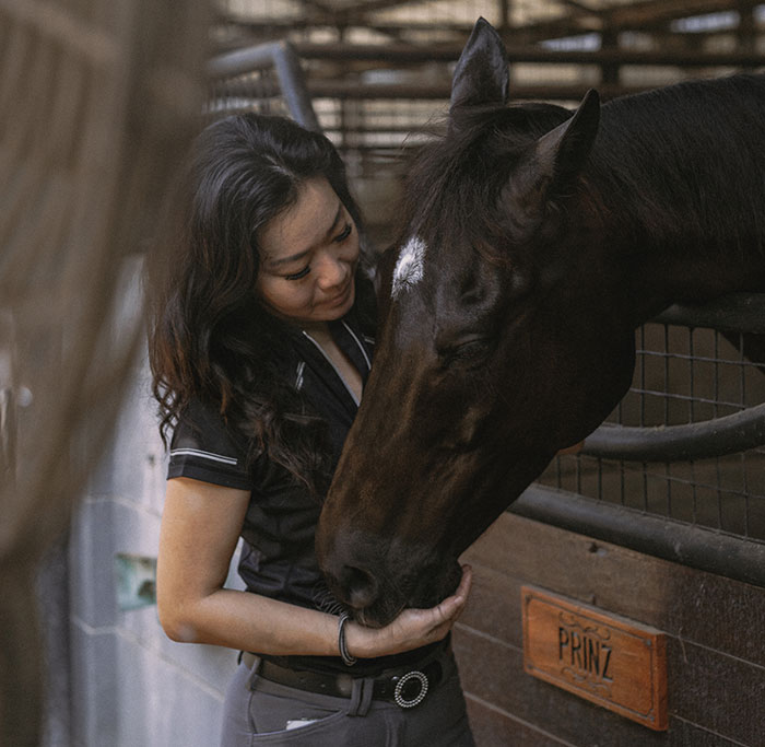Woman bonding with a horse at a stable, illustrating a unique moment amid worst proposal stories involving surprising partners.