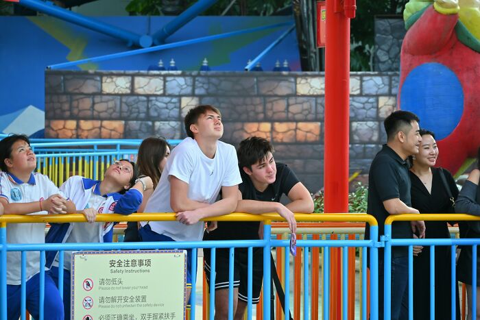 Group of people leaning on colorful railings outdoors, illustrating habits that affect mental and physical health long-term.