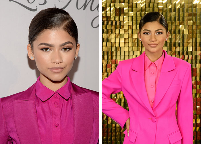 Madame Tussauds wax figure of a celebrity in a bright pink suit posed against a gold tiled backdrop
