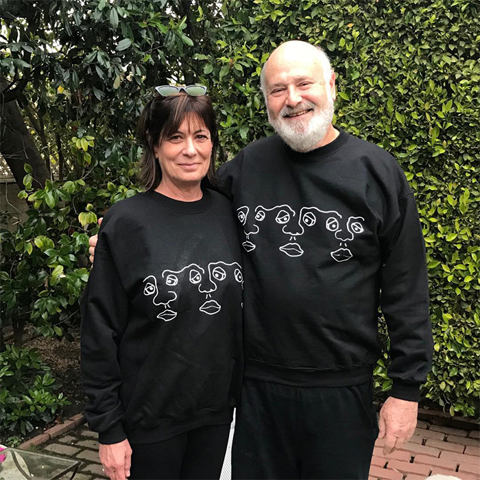 Nick Reiner&rsquo;s family posing together outdoors, wearing matching black sweatshirts with abstract face designs.